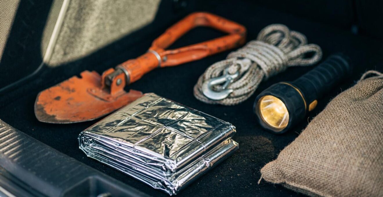 Kit de survie hivernal organisé dans le coffre d'une voiture avec pelle, couverture et équipements